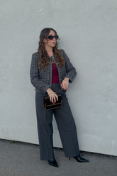 a lady in a red top, a sequin tweed jacket and a pair of grey wide leg pants